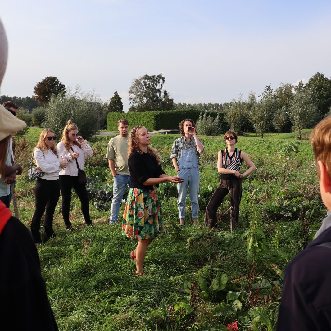 Een groep mensen in gesprek in de moestuin